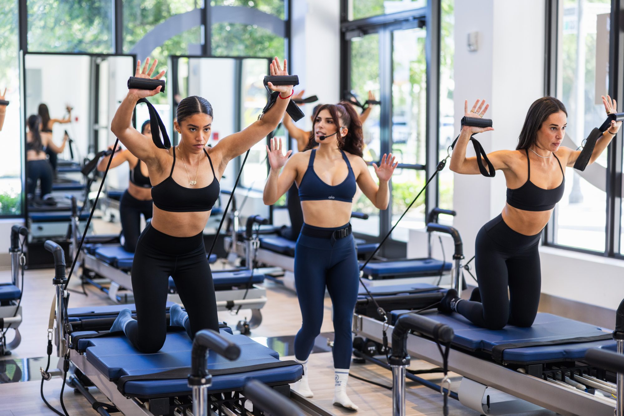 JETSET Pilates instructors leading a group reformer Pilates class inside the Training Academy.